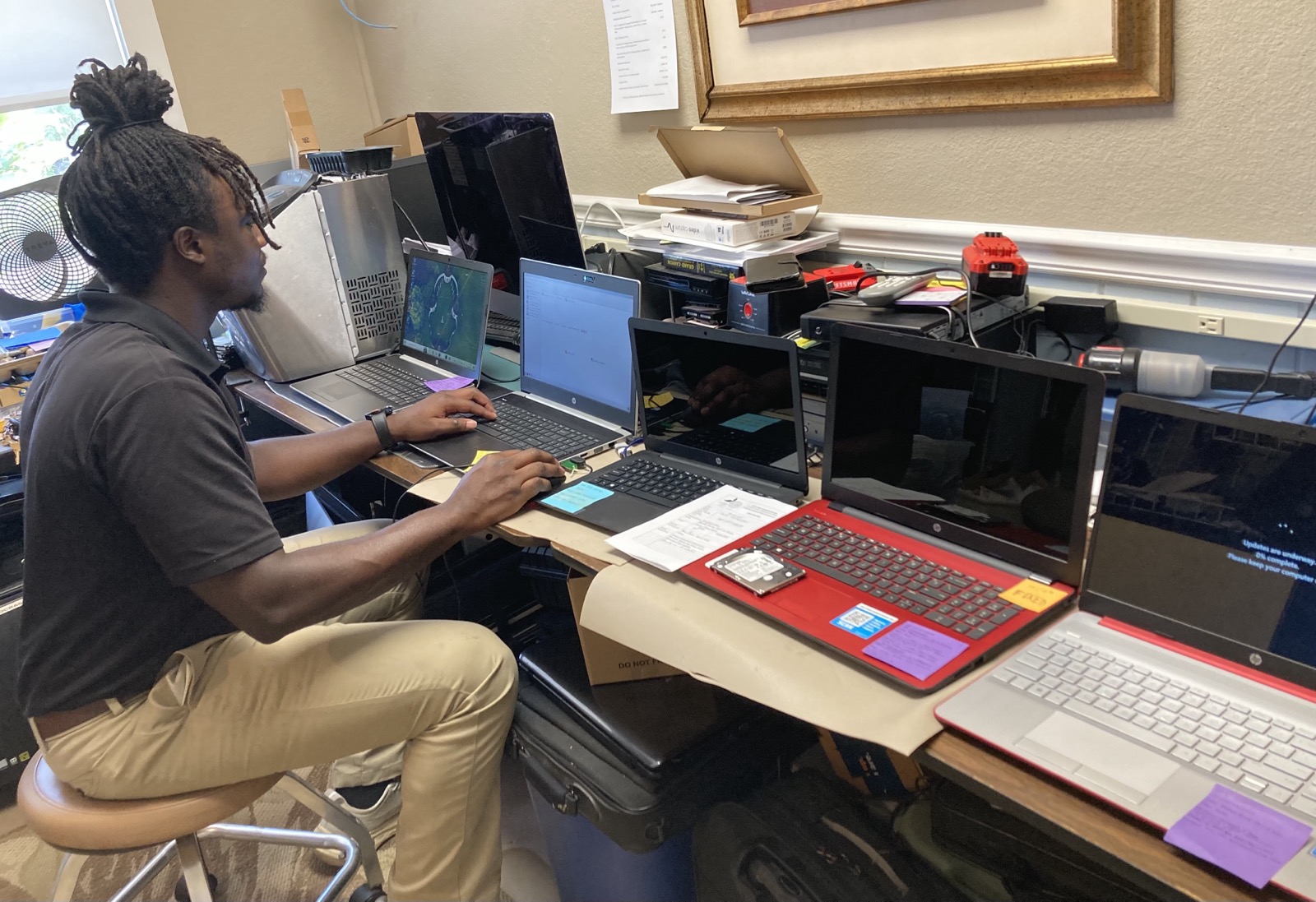 A technician working on laptops at the shop
