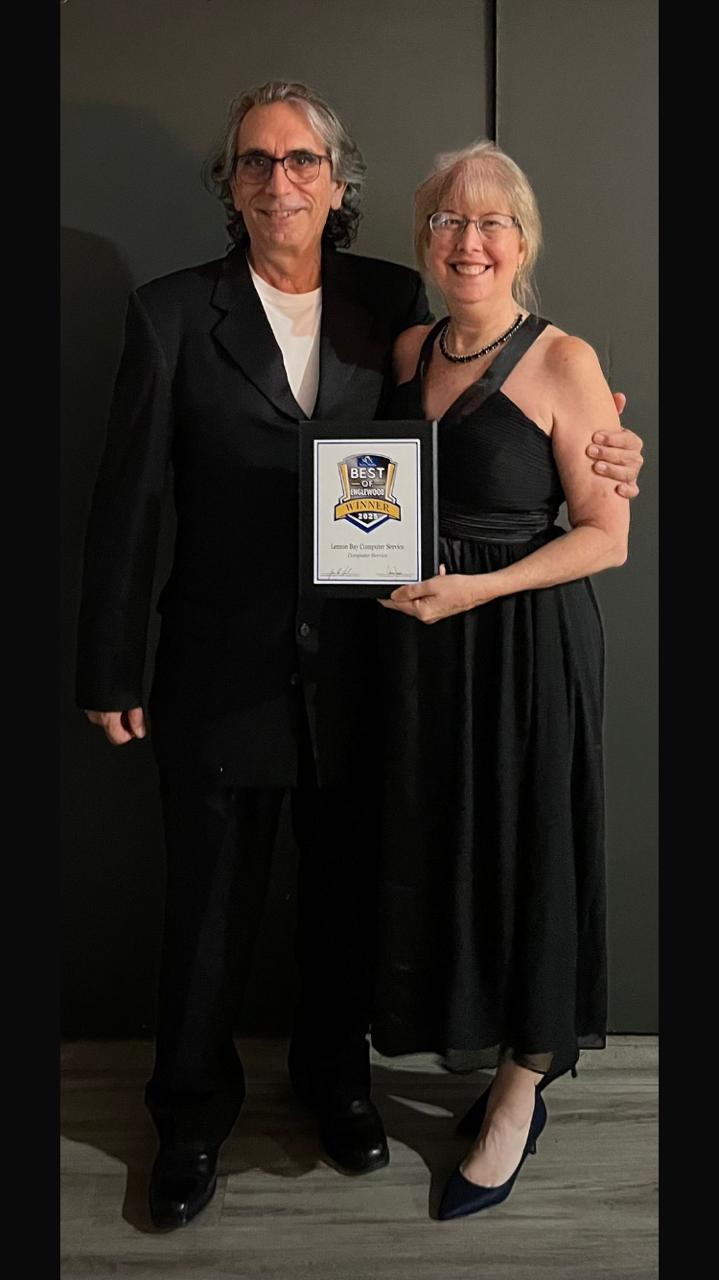 Two people holding a Best of Englewood award